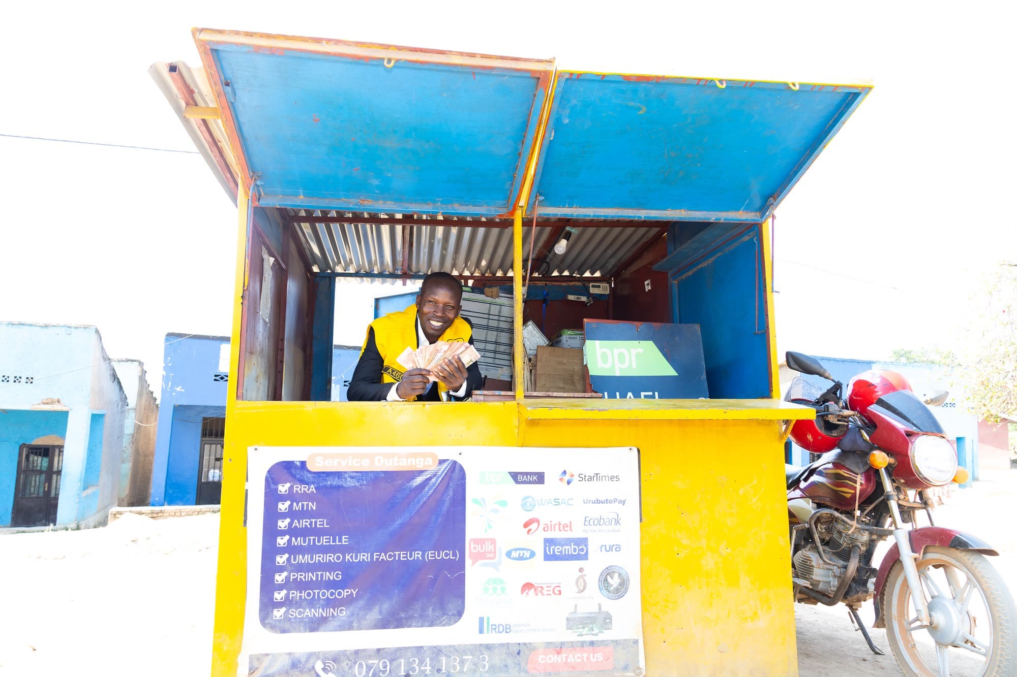 A young man running his mobile money and airtime kiosk